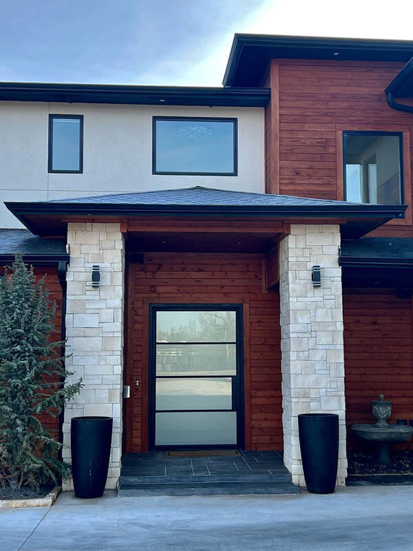 custom stone pillar and wooden plank entry way to home