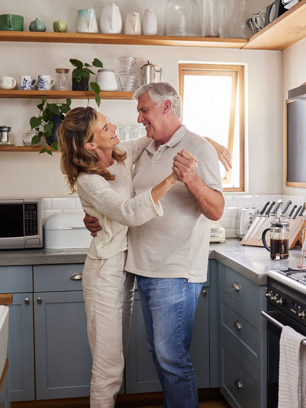 Mature couple dancing in luxury kitchen